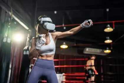 Asian sportswoman using innovative technology VR glasses for exercise.