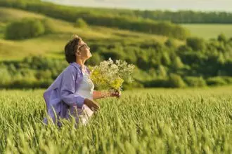 Elderly woman in stylish clothing relaxing in a lush meadow, embodying the fulfilling experiences